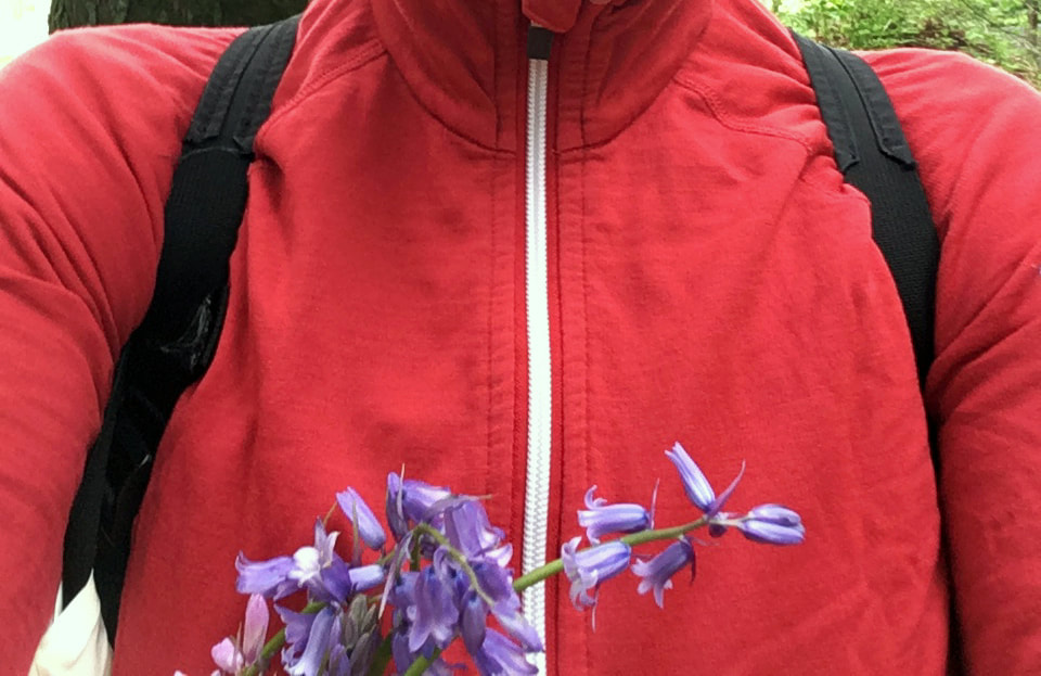 Close up of shoulders with backpack straps and flowers in the foreground